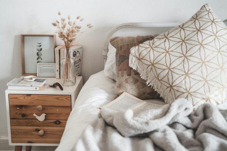 Gemütliches Schlafzimmer mit einem Bett, Kissen, einer Decke und einem Nachttisch.